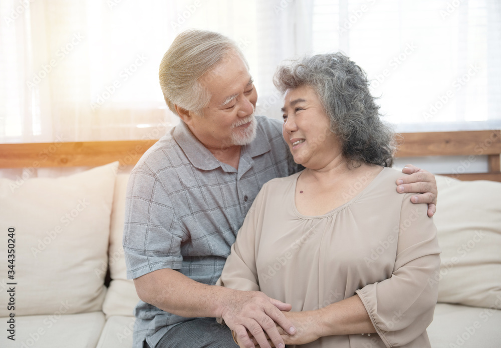 Elderly senior asian couple happy together at home.Grandfather and grandmother sit on coach in living room at home have leisure time in retirement lifestyles. Elderly senior asian couple happy together at home.Grandfather and grandmother sit on coach in living room at home have leisure time in retirement lifestyles.
