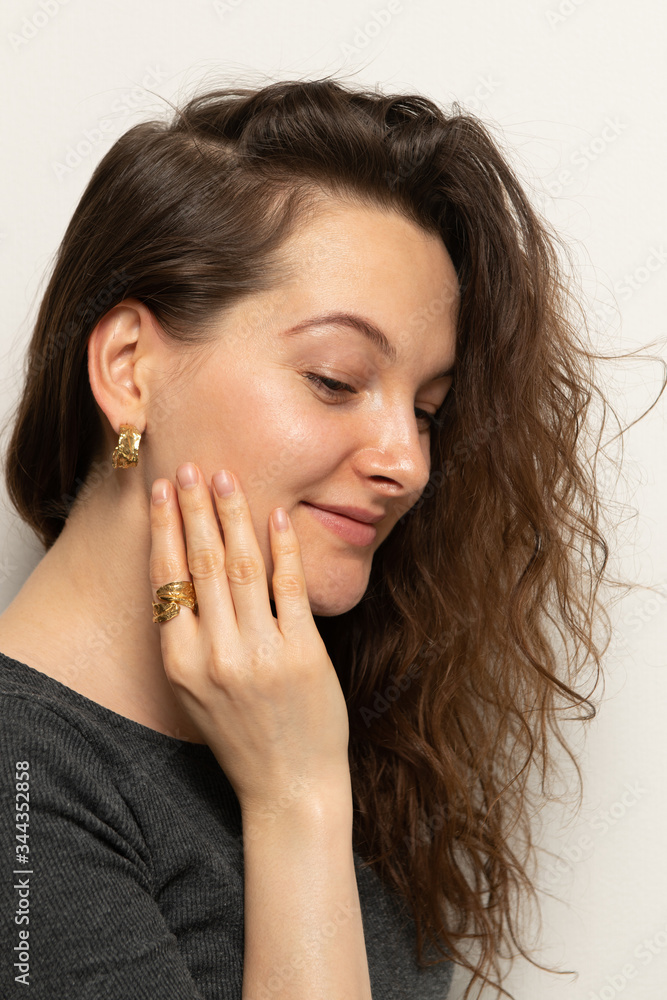 Portrait of beautiful woman wearing golden ring and golden earrings Portrait of beautiful woman wearing golden ring and golden earrings