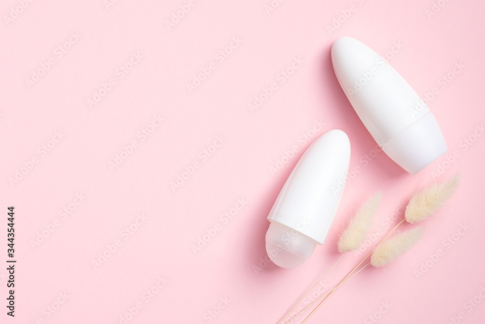 Minimal style deodorant packaging with dry flowers on pink background. Flat lay, top view. Blank antiperspirant bottles, sweat protection product concept Minimal style deodorant packaging with dry flowers on pink background. Flat lay, top view. Blank antiperspirant bottles, sweat protection product concept