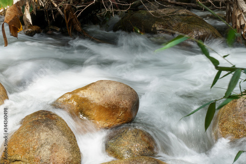 Rocks in creek or stream flowing water. photo