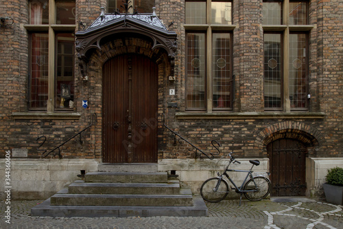 Detail of wooden door and brick facade with bicycle © AlejandroZaras