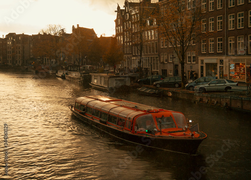 Amsterdam holland canal landscape with boats at cloudy sunset