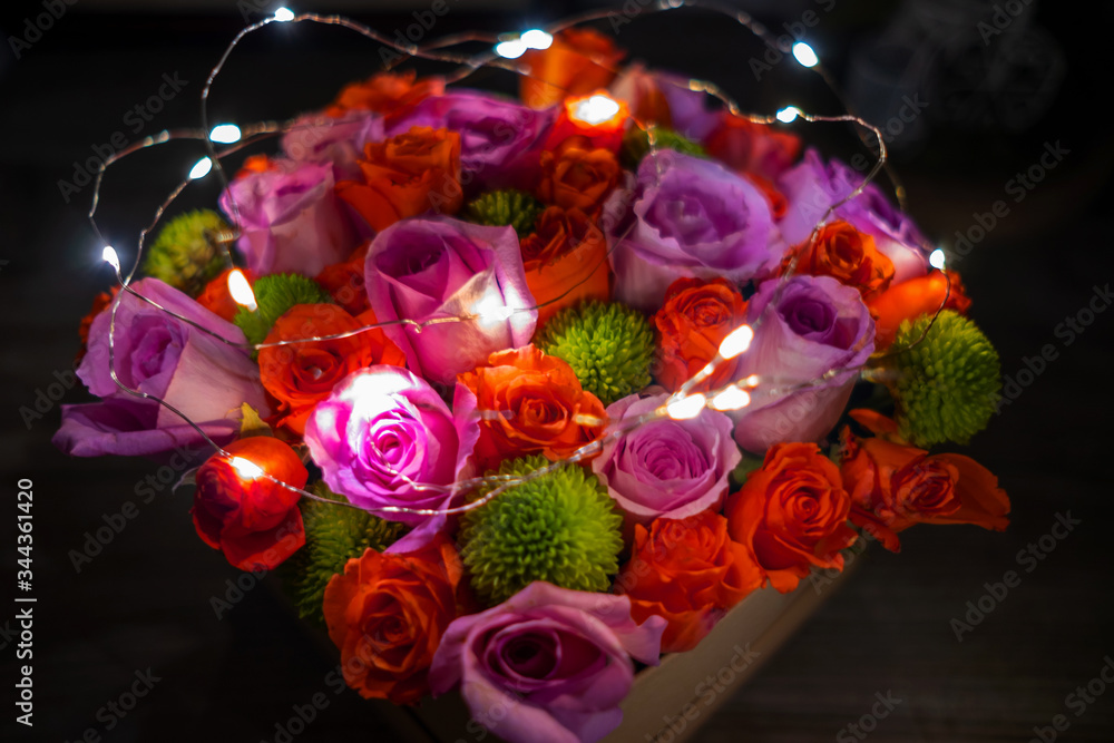 Obraz premium Top view of bunch or bouquet of roses with tiny lights in the box, gift for happy mother's day