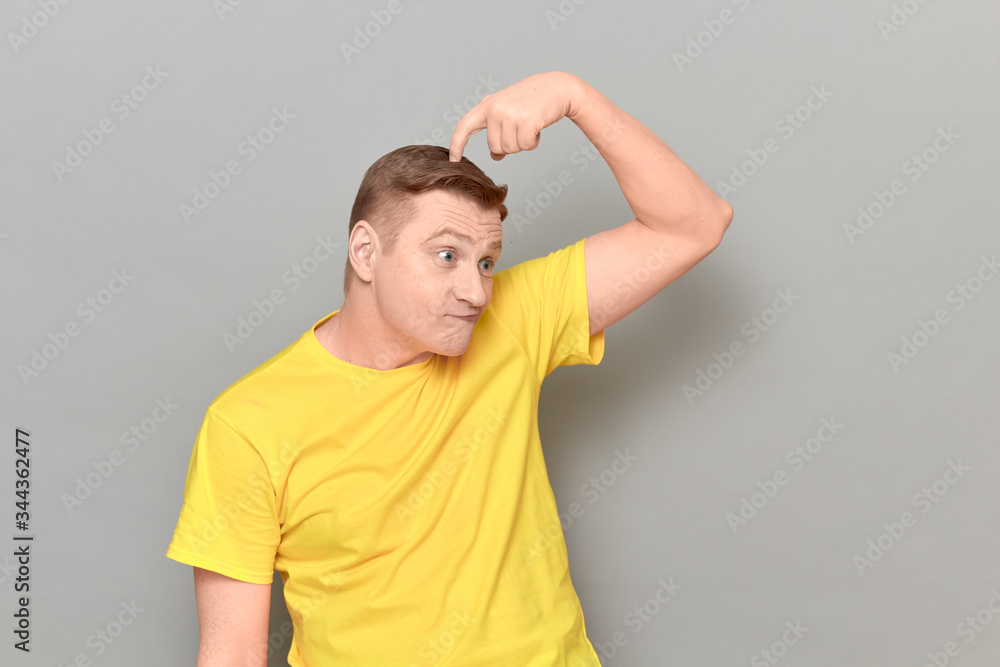 Portrait of puzzled man scratching head with finger and thinking hard Portrait of puzzled man scratching head with finger and thinking hard