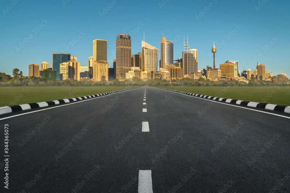 asphalt road in perspective view with urban cityscape in sunset, empty highway with skyline city skyscraper in Sydney