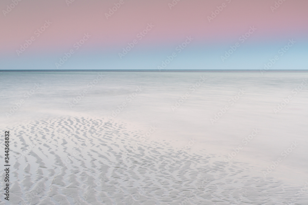 white sandy beach with pastel sky at dawn