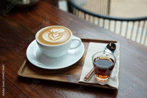 Fotografie Hot coffee latte on white coffee cup sering with brown sugar syrup on timber tab