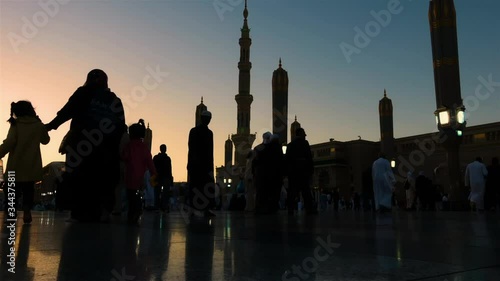 Medina, Saudi Arabia – MARCH 20, 2019: Timelapse of Pilgrims walking outside of Nabawi Mosque,Medina during sunset. photo