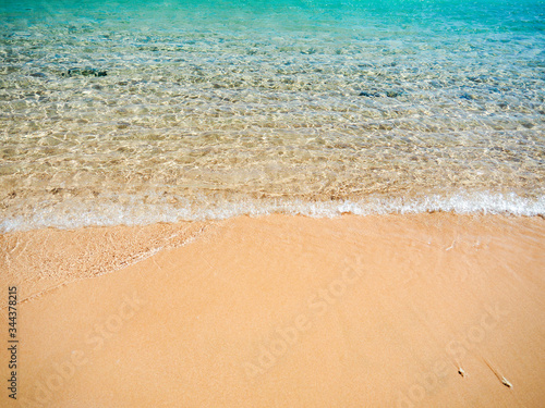 Red Sea beach in february. Rippling water surface on shallow, medium view. Yellow sand on beach. Selective soft focus. Blurred background