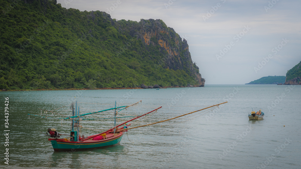 Traditional Thail fishing boat with reflection at mooring in the sea Traditional Thail fishing boat with reflection at mooring in the sea
