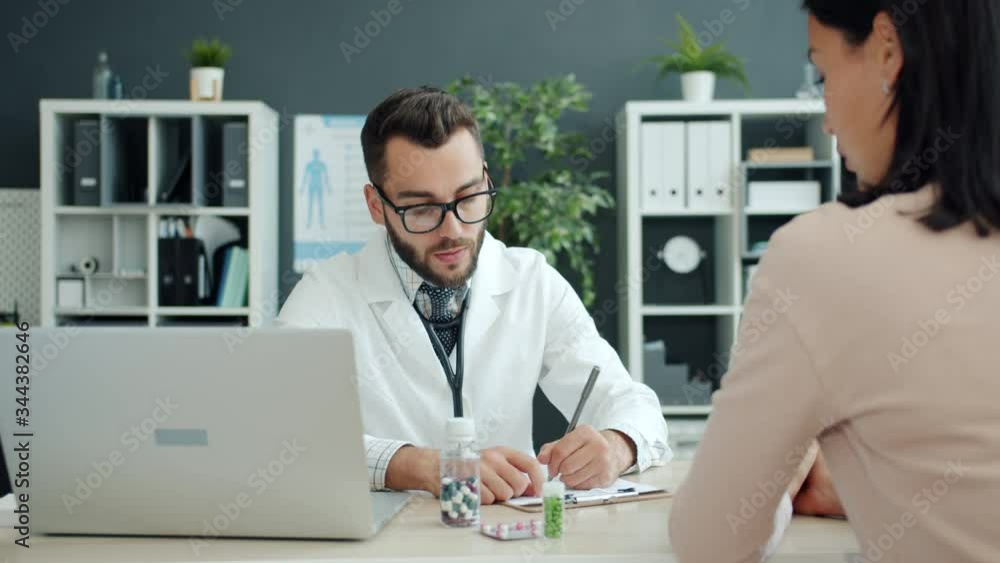 Medical specialist in glasses and uniform is talking to girl patient prescribing medication in hospital talking writing. People, clinic and healthcare concept. Medical specialist in glasses and uniform is talking to girl patient prescribing medication in hospital talking writing. People, clinic and healthcare concept.