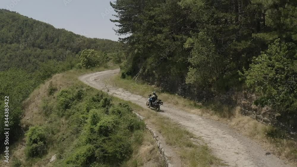 Aerial view of biker on road through forest Aerial view of biker on road through forest