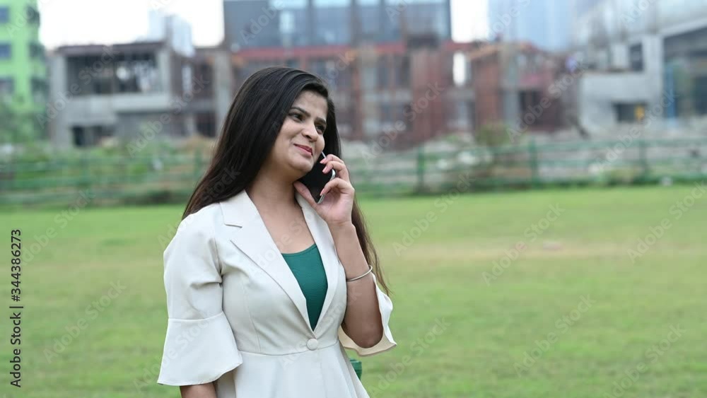 Young beautiful business woman (student) in a suit talking on mobile phone in outdoor location. Business, communication, banker concept. Young beautiful business woman (student) in a suit talking on mobile phone in outdoor location. Business, communication, banker concept.