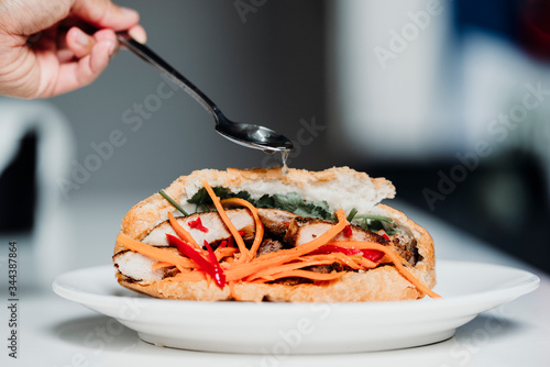 Banh mi is the traditional vietnamese sandwich made with pickled carrot, lettuce, fish sauce and and meat. Concept: asian street food photo