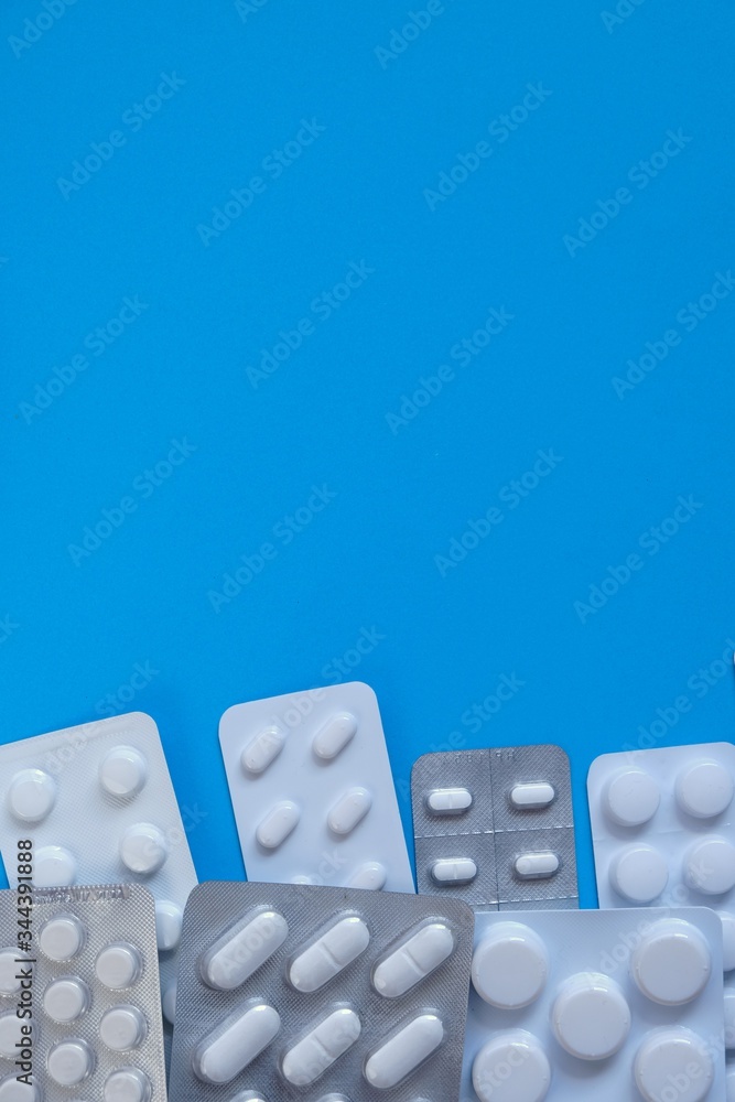 Pills packing. Pills set on a bright blue background.Health and medicine .Medicinal drug.Cold and flu.Treatment and prevention of viral diseases.copy space.Medication and prescription pills. Pills packing. Pills set on a bright blue background.Health and medicine .Medicinal drug.Cold and flu.Treatment and prevention of viral diseases.copy space.Medication and prescription pills.
