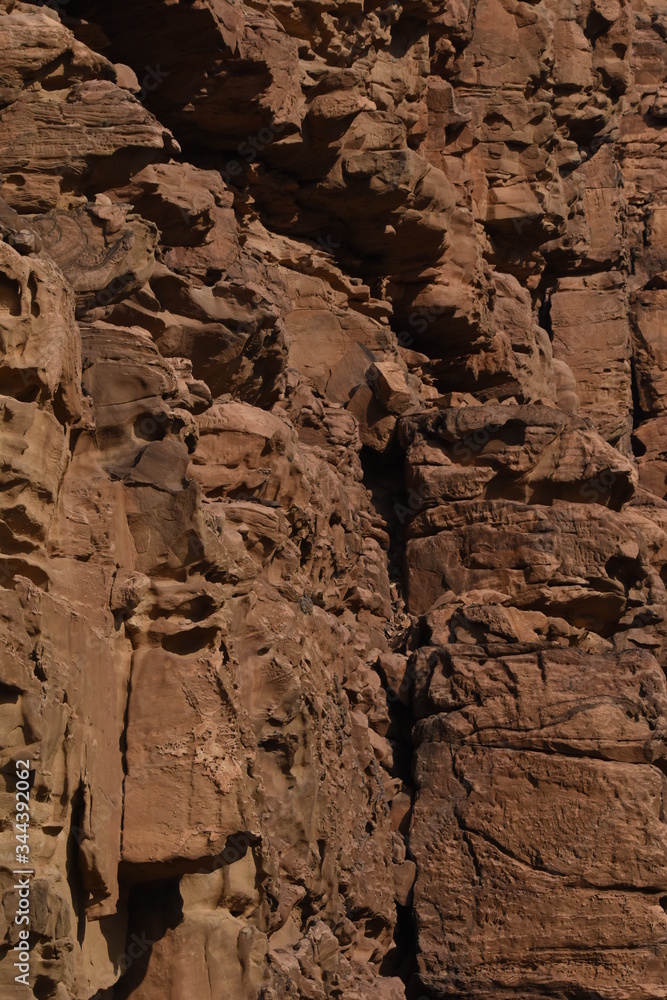 Obraz premium Entrance to the Wadi Mujib canyon in Jordan. Steep rocks and a rapid flowing river carved. Difficult crossing and attraction for tourists on the water route.