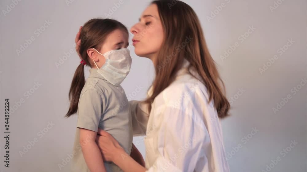 The doctor puts a medical mask on the child. The mother treats the child. Demonstration of medical equipment. The concept of quarantine, self-isolation, protection from coronavirus, virus, fear of dis The doctor puts a medical mask on the child. The mother treats the child. Demonstration of medical equipment. The concept of quarantine, self-isolation, protection from coronavirus, virus, fear of dis
