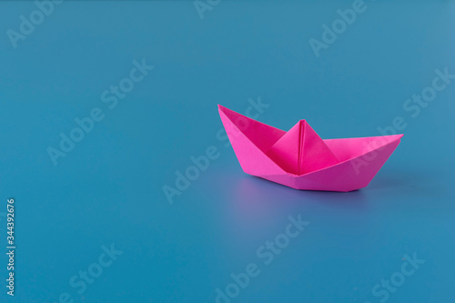 Paper boat on a blue background. Columbus Day