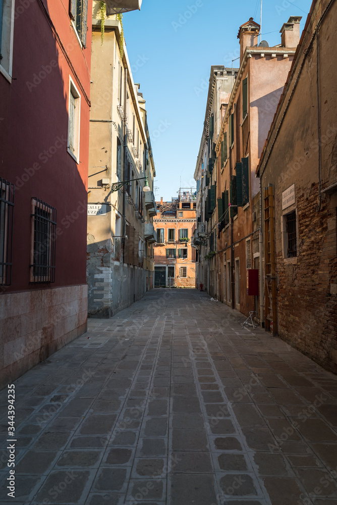 Looking down an old Venetian alleyway between two old buildings in the town of Venice in Italy