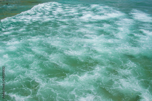 Sea texture, beautiful turquoise water waves with white foam, powerful nature concept, full frame, ocean
