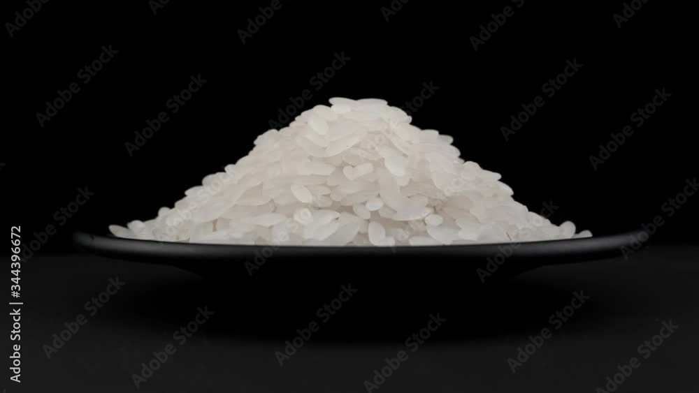 Rice grains of spin around themselves on a black background and ground Rice grains of spin around themselves on a black background and ground