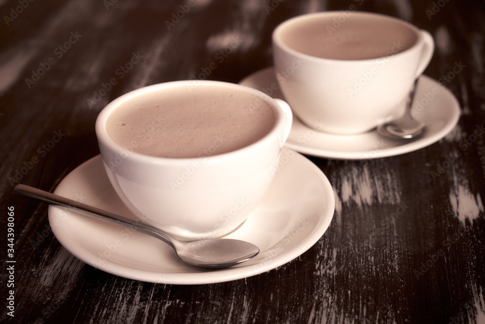 Two cups of coffee on a wooden table. Two cups of coffee on a wooden table.