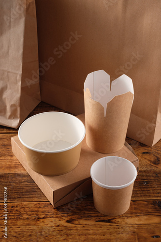 Street fast food paper cups, plates and containers. Eco-friendly food packaging on wooden background. Carering of nature and recycling concept.