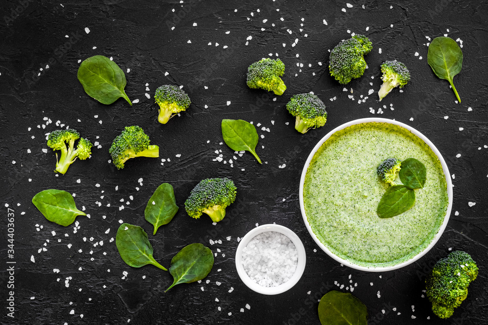 Green vegetable cream soup - broccoli - on black kitchen table top view Green vegetable cream soup - broccoli - on black kitchen table top view