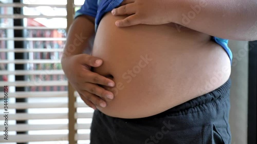 Slow motion of asian boy very fat scratching belly  
