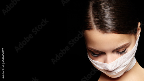 Beautiful woman with bandage mask on face. Fashion eye make-up. Beauty surgery or protection hygiene in virus pandemic photo