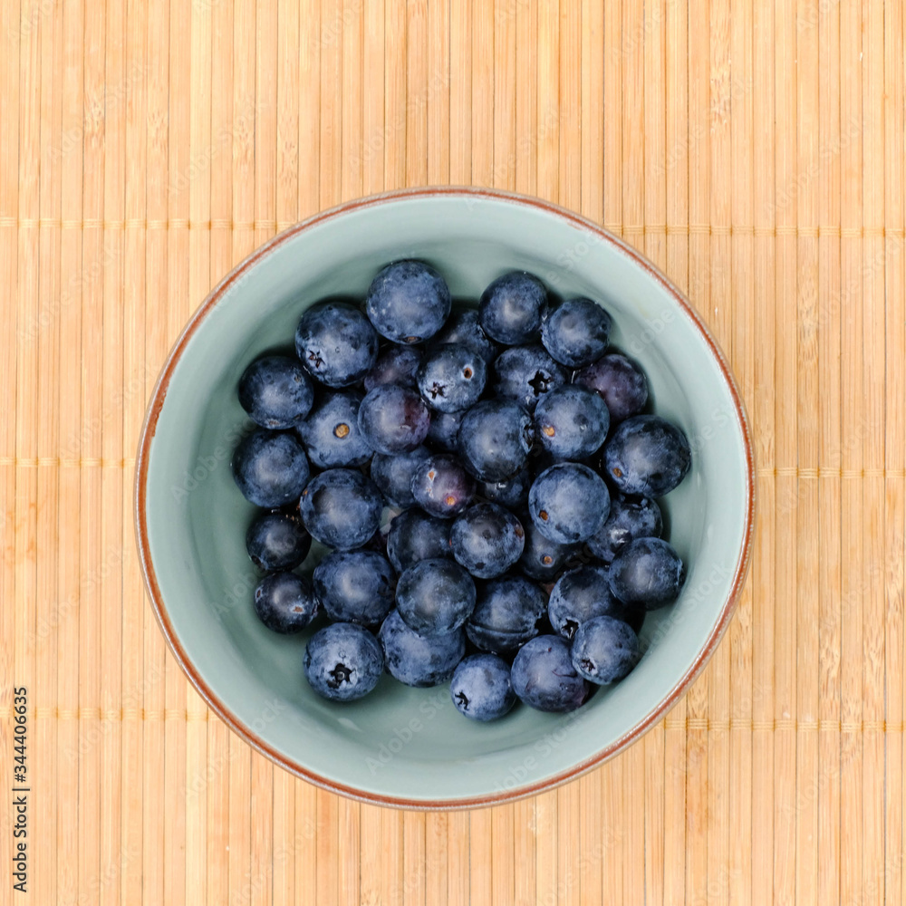 Freshly picked blueberries in bowl. Juicy and fresh blueberry with green leaves on rustic table. Bilberry on wooden Background. sparkleberry antioxidant. Concept for healthy eating Freshly picked blueberries in bowl. Juicy and fresh blueberry with green leaves on rustic table. Bilberry on wooden Background. sparkleberry antioxidant. Concept for healthy eating