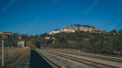 The famous city of Stanjel, a village on a hill in Karst region of Slovenia on a sunny day, viewed from the train station platform. photo