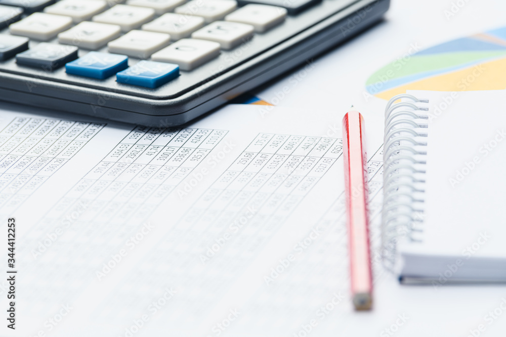 Business financial documents, office calculator and pen on the table. Numbers and graphs Business financial documents, office calculator and pen on the table. Numbers and graphs