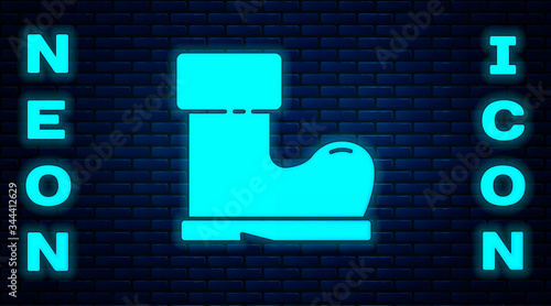Glowing neon Waterproof rubber boot icon isolated on brick wall background. Gumboots for rainy weather, fishing, gardening. Vector Illustration