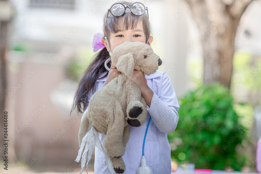 Close-up background view of a cute girl, who is experimenting with learning outside the classroom during the holidays, medical simulations to treat animals using accessories Close-up background view of a cute girl, who is experimenting with learning outside the classroom during the holidays, medical simulations to treat animals using accessories