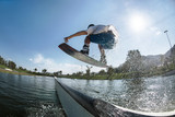 Wakeboarder jumps at ramp at wake park