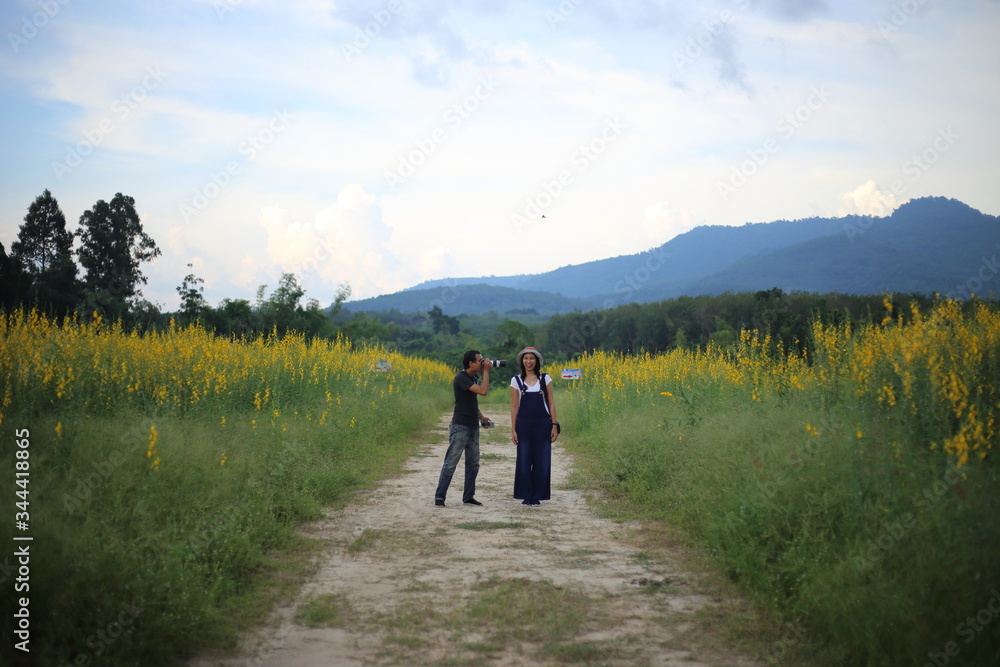 Women and men take pictures in the crotalaria juncea field in Rayong, Thailand.