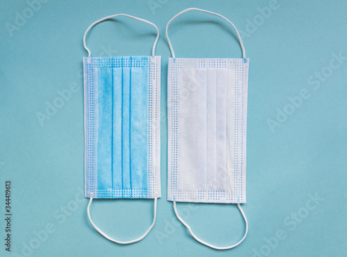 Two sides of medical mask on green background with copy space. hygienic quarantine concept. Flat lay, top view
