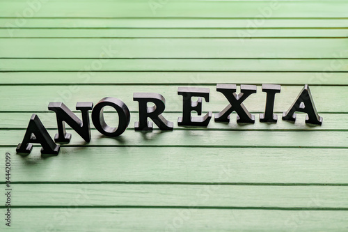 Word ANOREXIA on wooden background