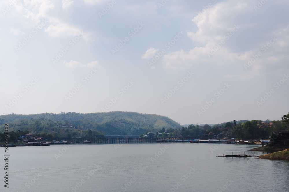 warm country lake, bridge and low-rising mountains