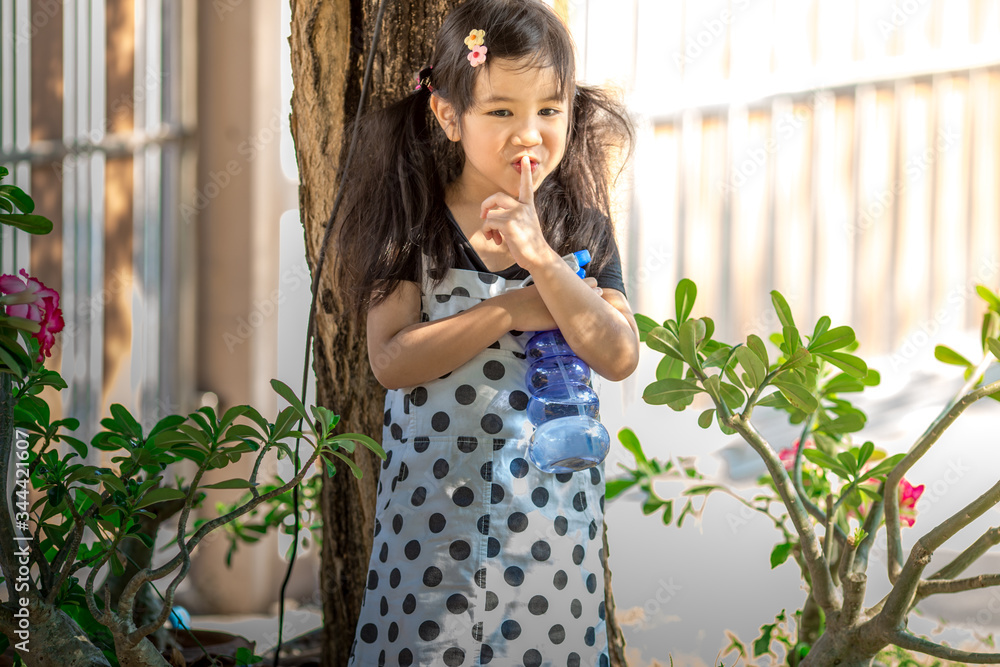 Close-up background view of a cute girl who is watering plants or growing vegetables for health, a crop cultivation program and business expansion. Close-up background view of a cute girl who is watering plants or growing vegetables for health, a crop cultivation program and business expansion.