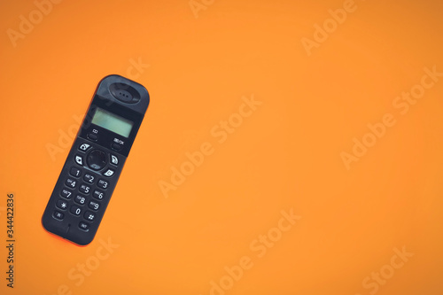 Wireless cordless telephone, radiotelephone, dect cordless phone on orange background. Copy space. photo