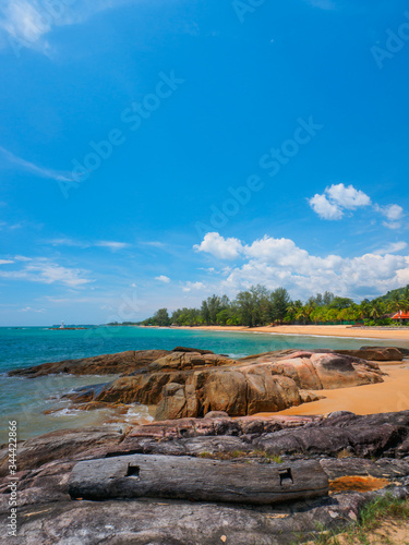 Uninhabited tropical rocky beach with blue sky