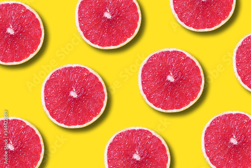 Grapefruit pattern on yellow background. Top view. Creative design  minimal flat lay concept. Summer time. Tropical travel  exotic fruit. Vegan and vegetarian food