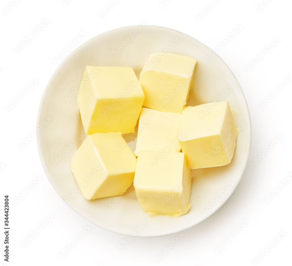 Butter pieces in white bowl isolated. Butter cubes. Top view. Butter pieces in white bowl isolated. Butter cubes. Top view.