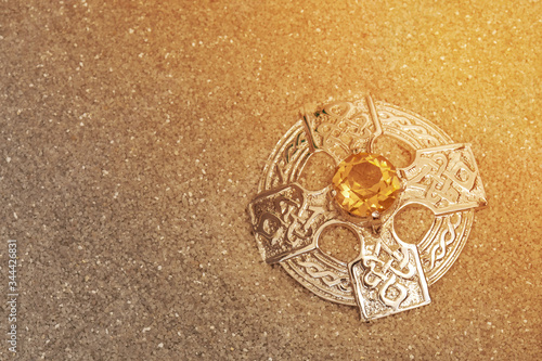 Φωτογραφία Silver antique old Celtic brooch with amber gemstone in sand