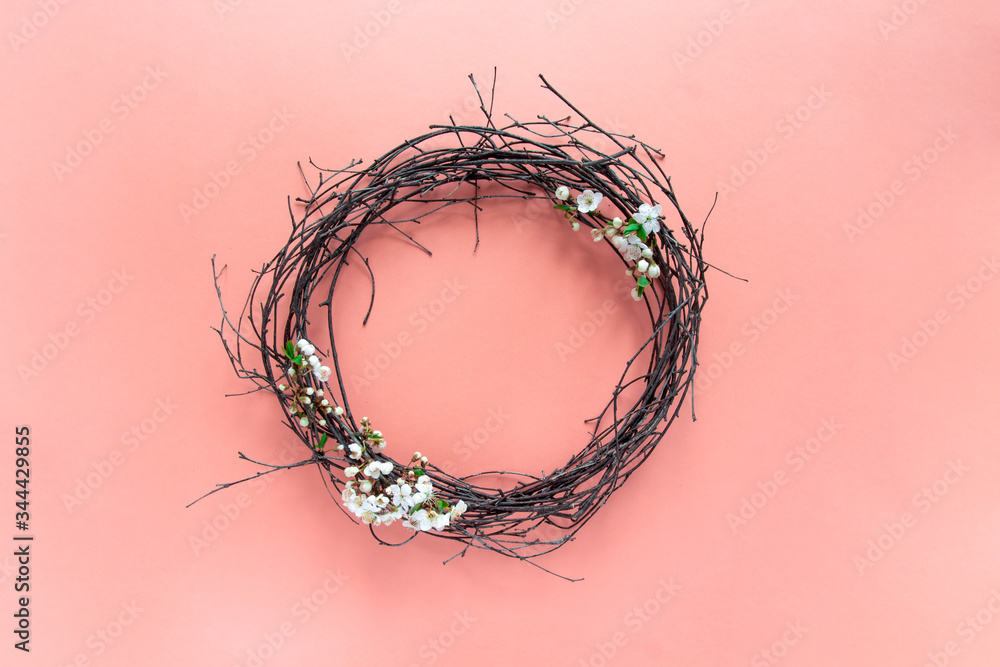 Fototapeta premium on a pink background, spring decorative wreath of branches of flowering cherry trees. room design