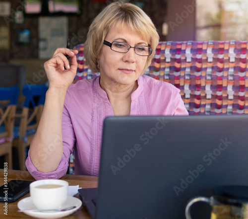 A woman is working with a laptop at a table in the room