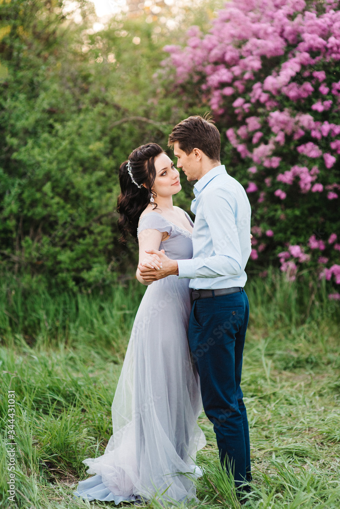 a guy and a girl walk in the spring garden of lilacs a guy and a girl walk in the spring garden of lilacs