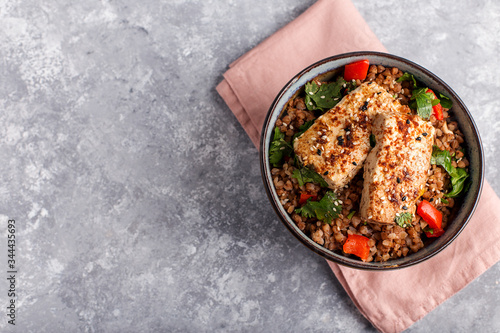 buckweat with tofu and pepper on a grey background